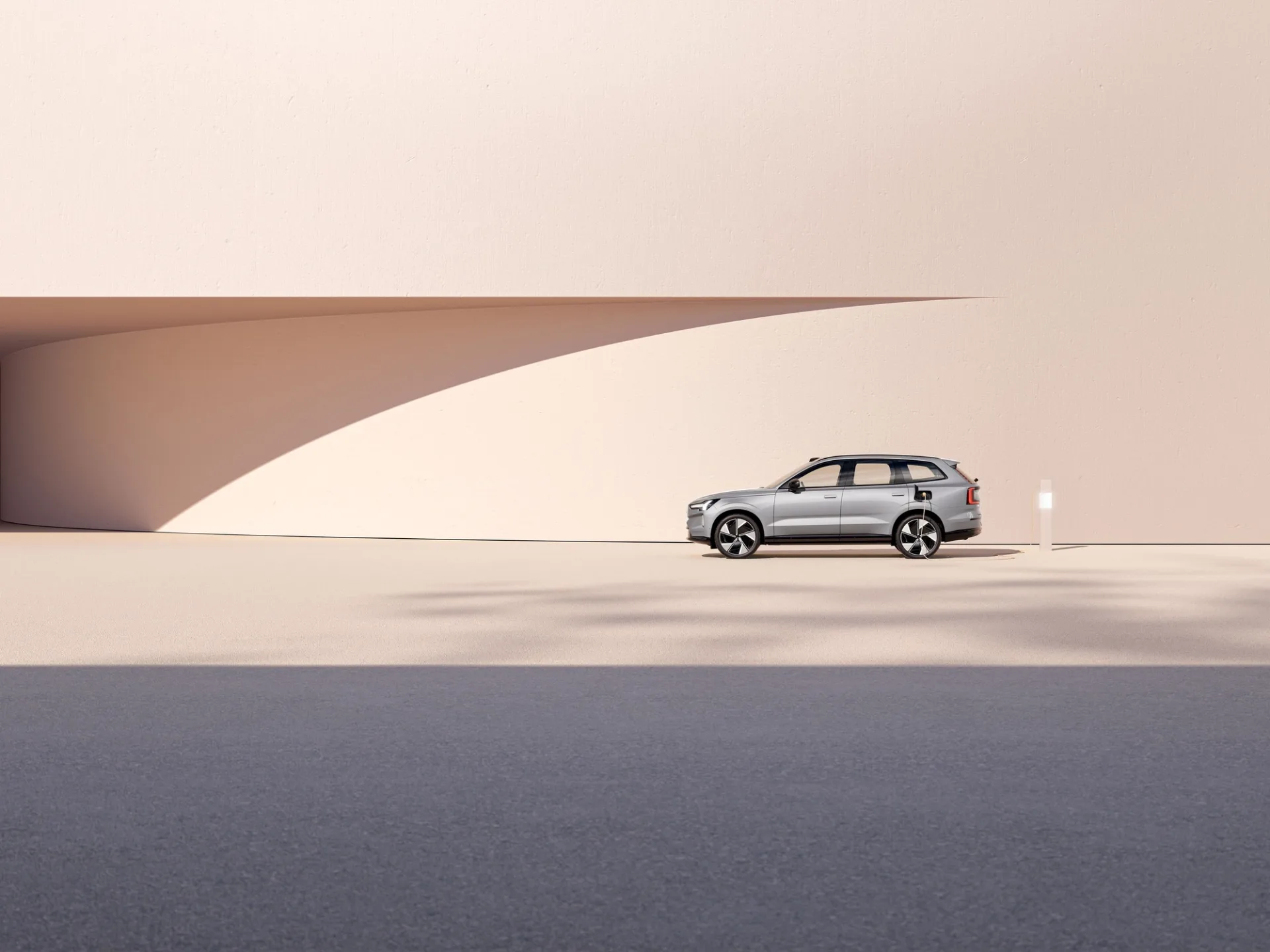 A Volvo EX90 parked in a pale minimal architectural setting