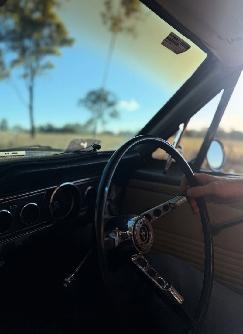 Jen driving a Mustang car on an open road