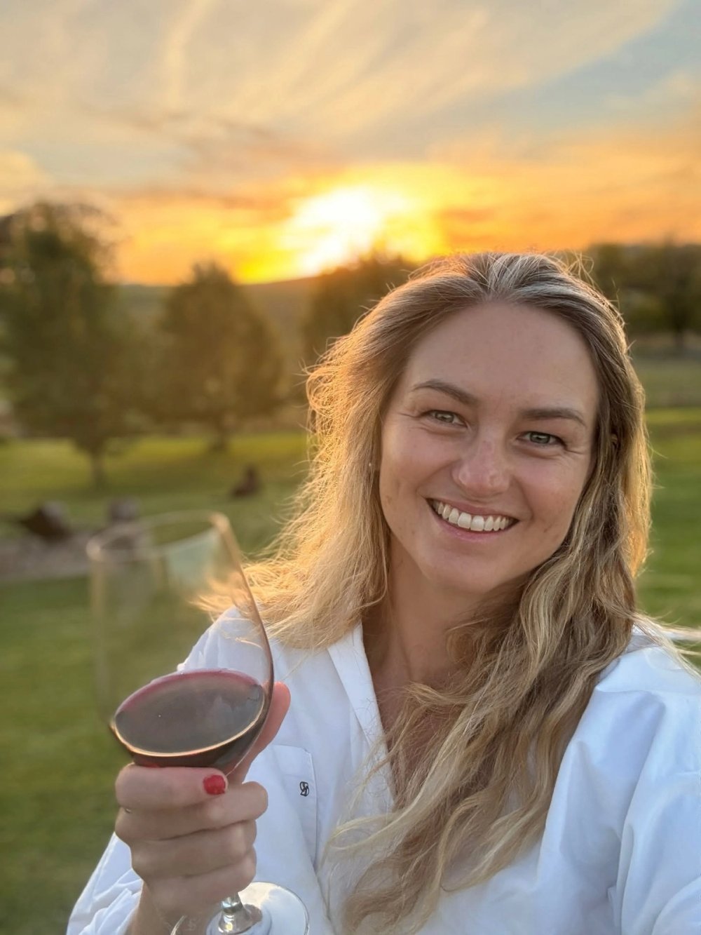 Jen with a glass of red at sunset during Easter in Orange