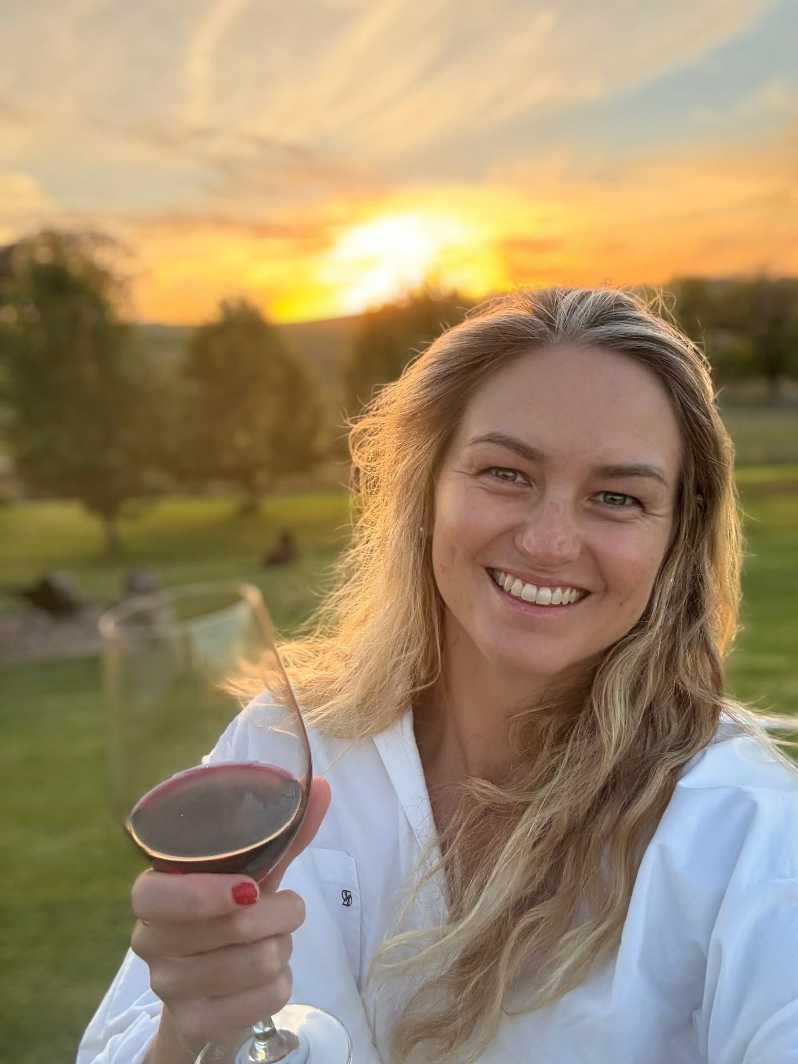 Jen with a glass of red at sunset during Easter in Orange