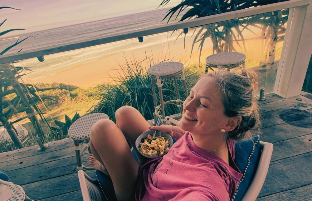 Jen eating breakfast on the balcony of her Yamba cottage overlooking the beach