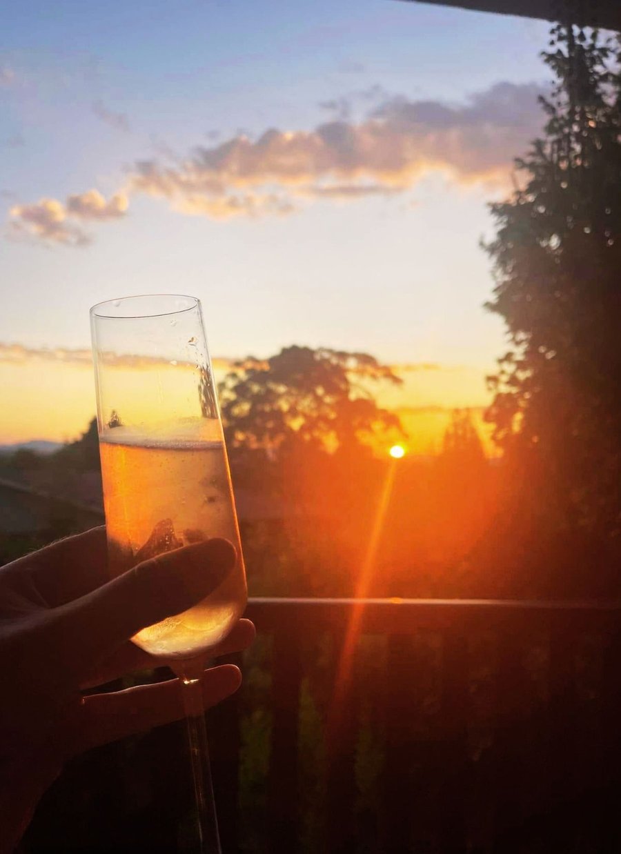 Jen enjoying champagne on a balcony watching the sunset
