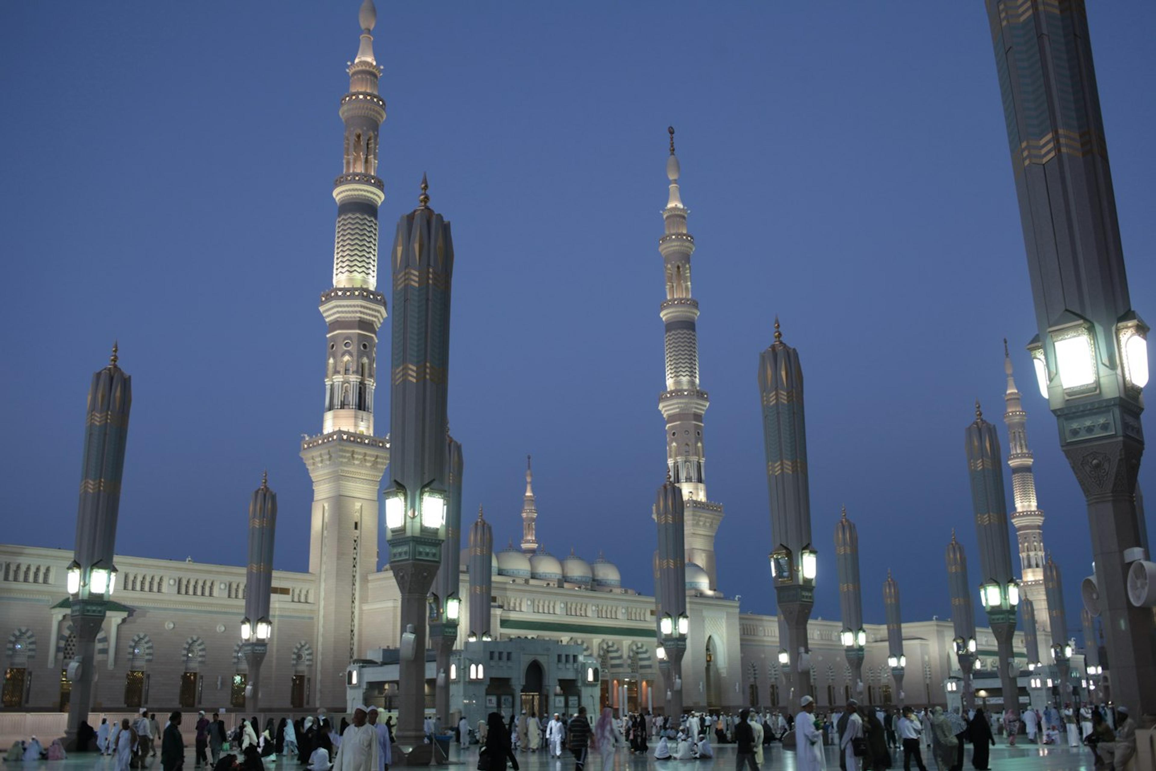 Masjid Nabawi saat senja dengan menara dan lampu