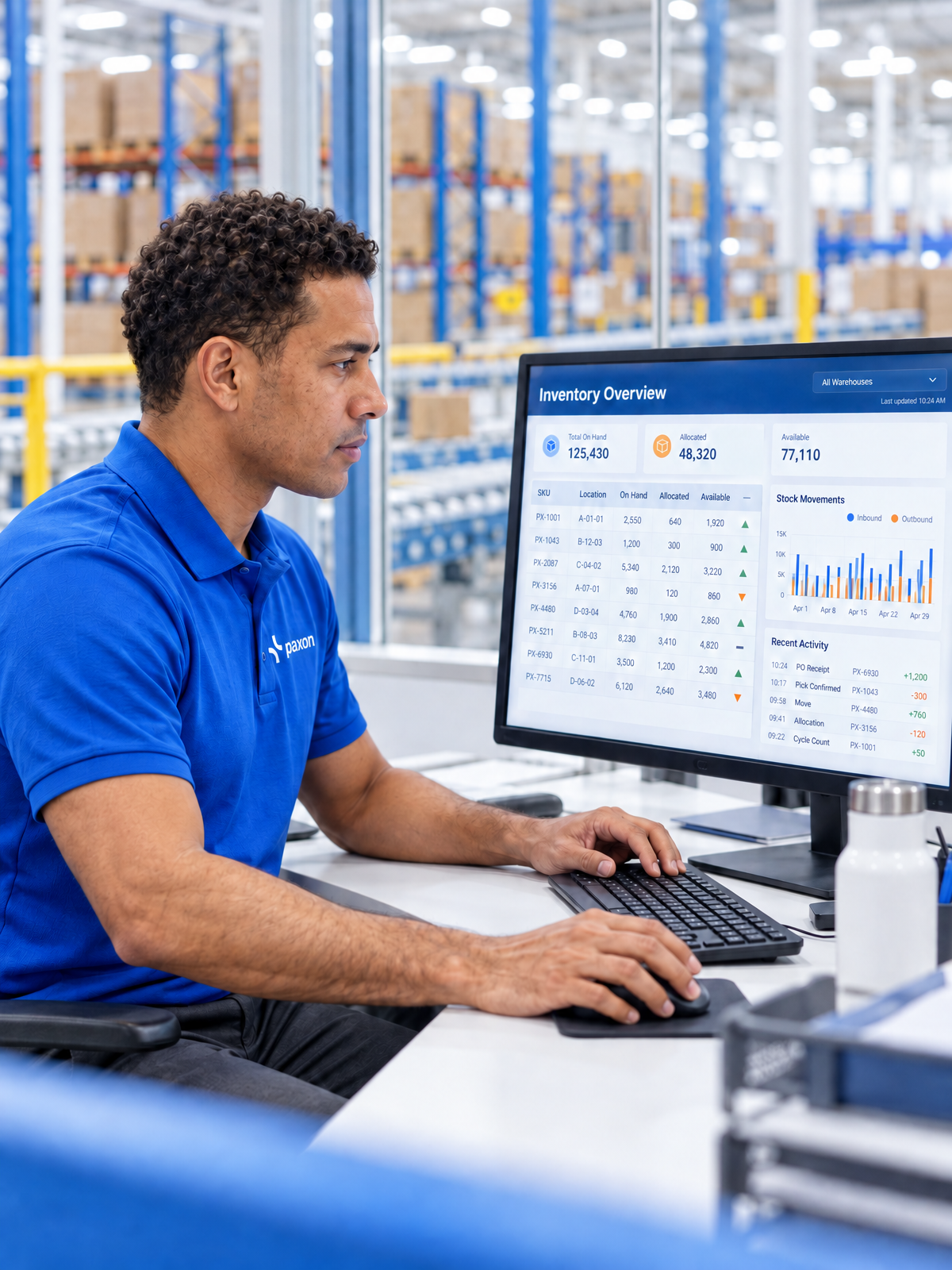 A man views inventory data on a computer in a warehouse.