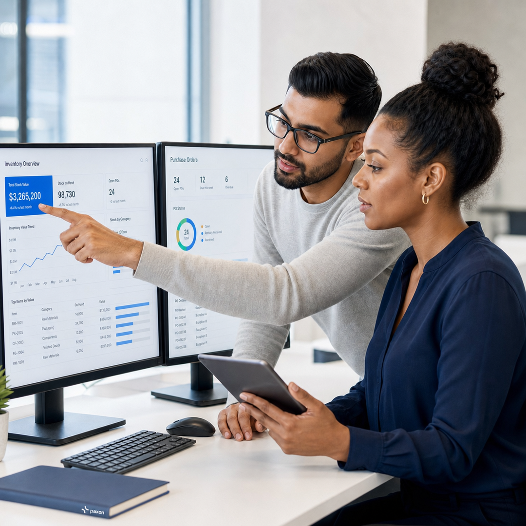 Two professionals analyzing data on computer monitors.
