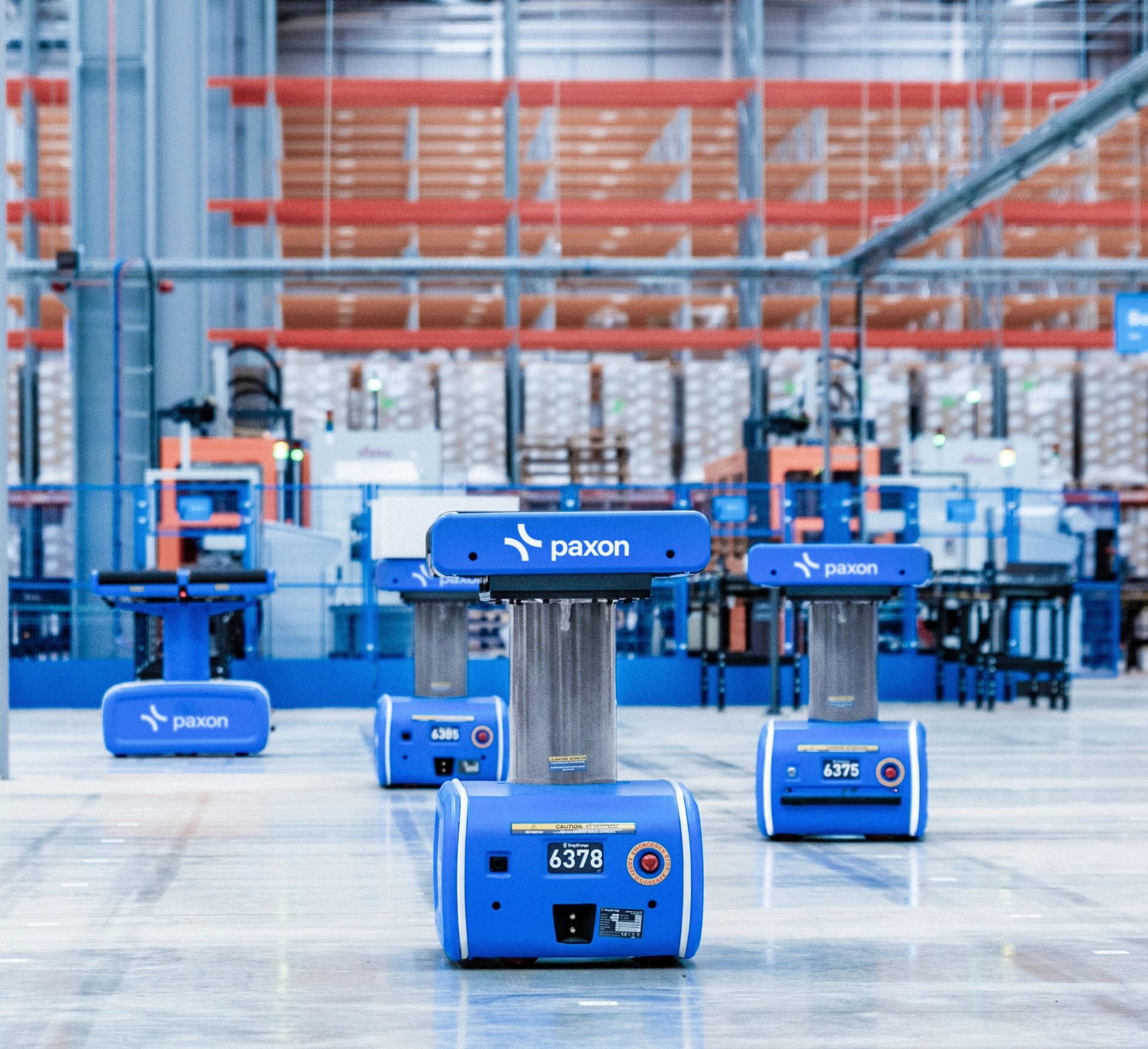 Robots mobiles autonomes bleus de Paxon dans un entrepôt.