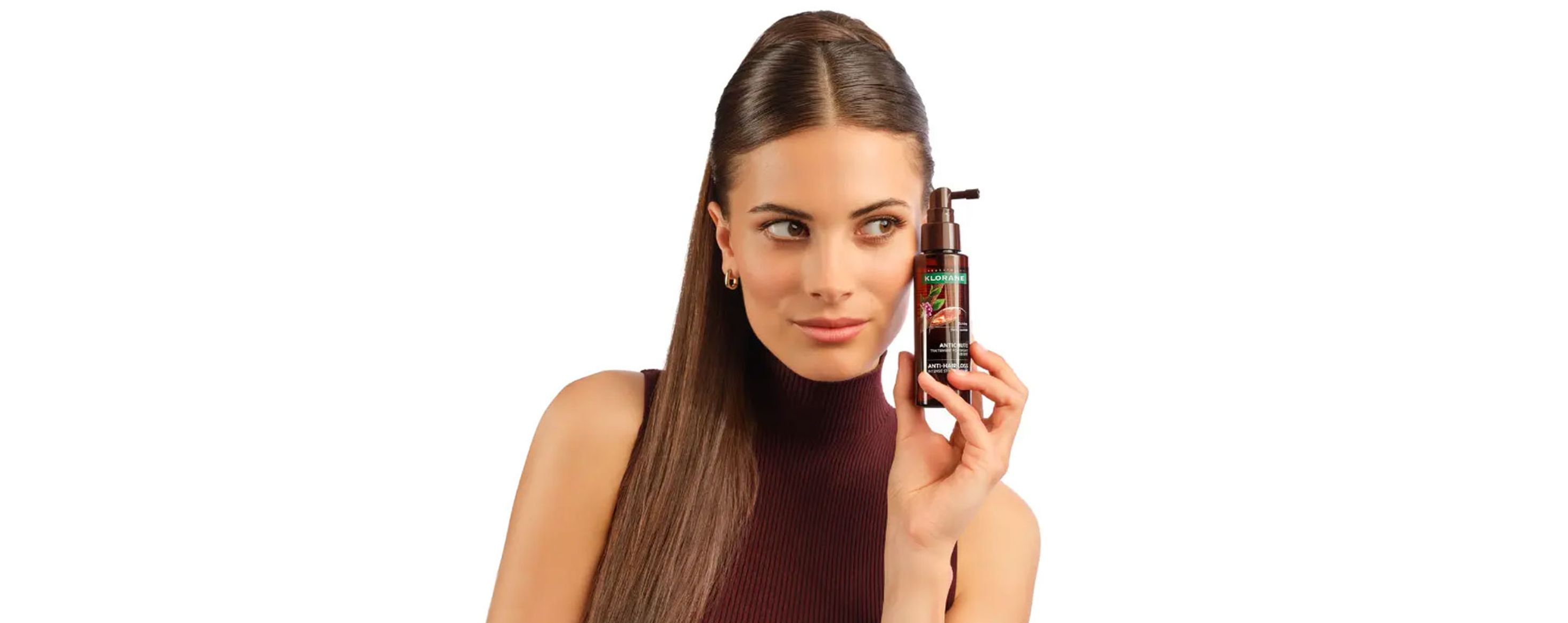 A woman with long hair holding a pump bottle.