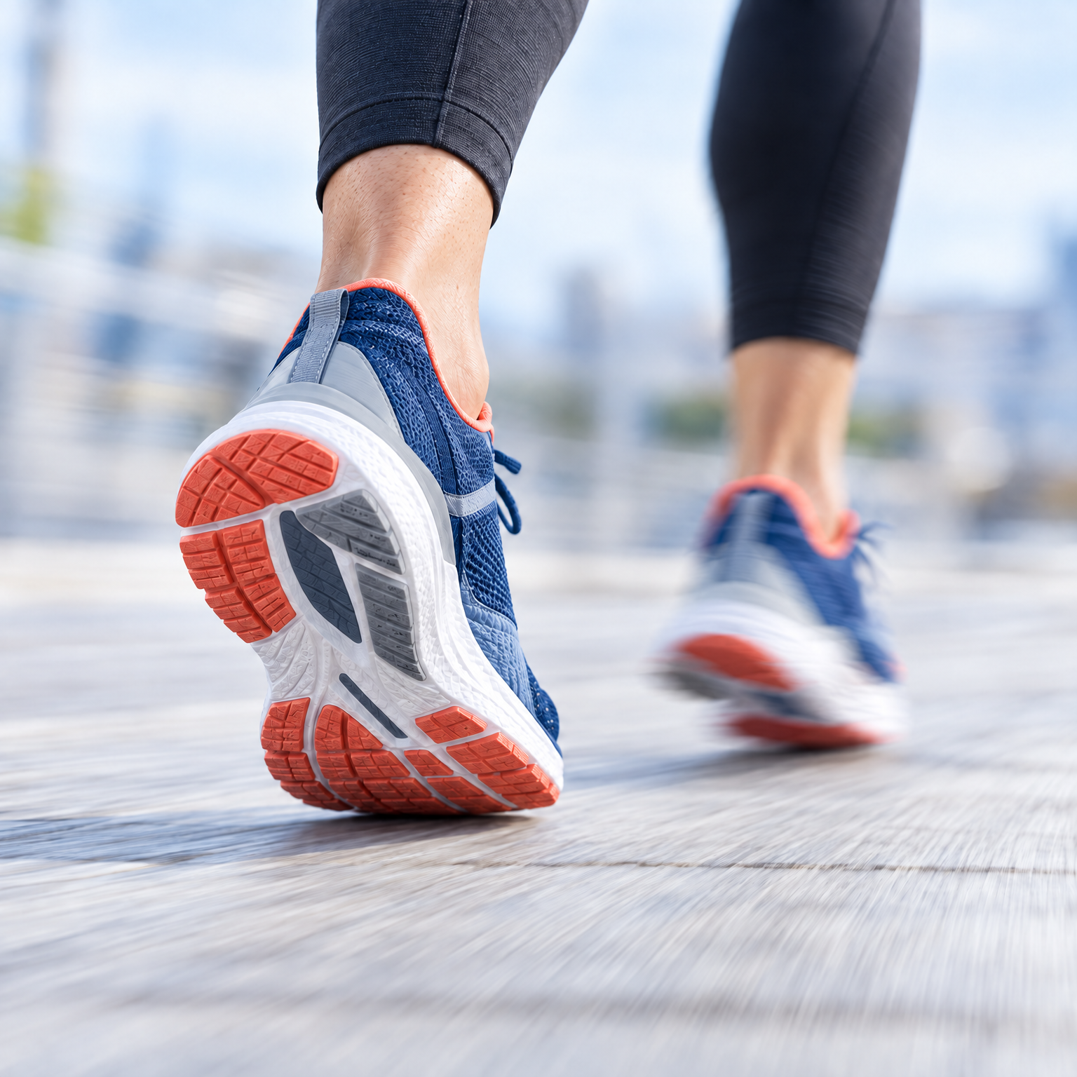 Person running in blue and orange sneakers, viewed from behind.