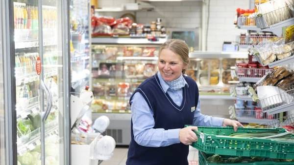 Smilende Joker-ansatt plasserer varer