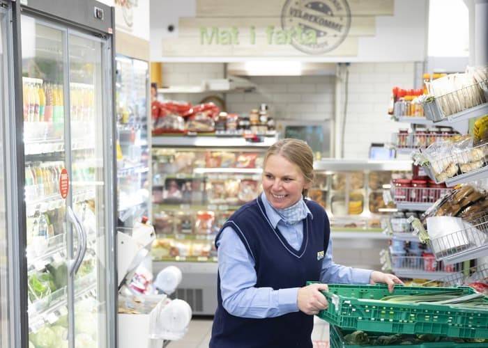 Smilende Joker-ansatt plasserer varer