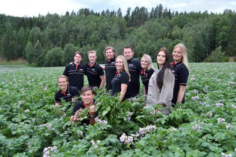 Butikkansatte stående ute i en åker