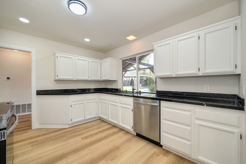 Modern kitchen featuring white cabinets and black counter tops for a stylish look.