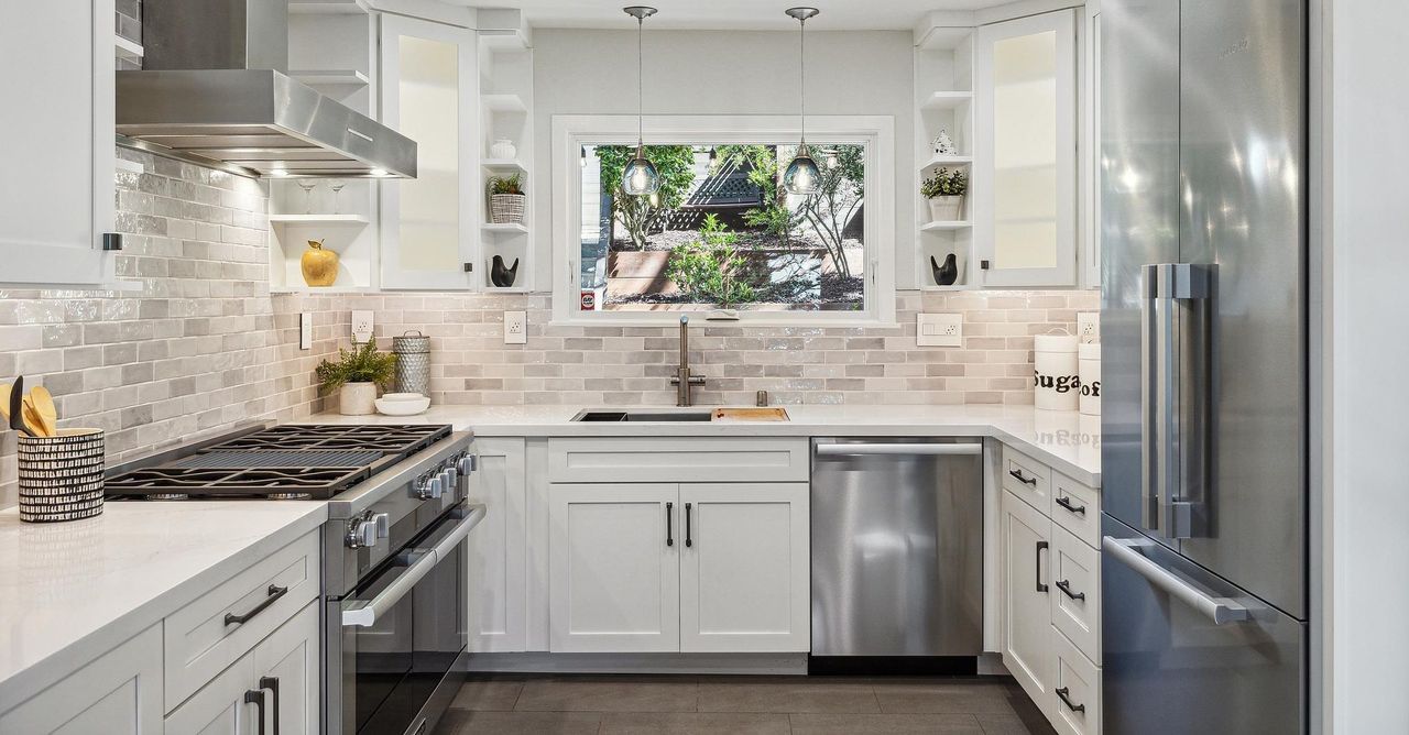 White Modern kitchen with stainless steel appliances and white cabinets.