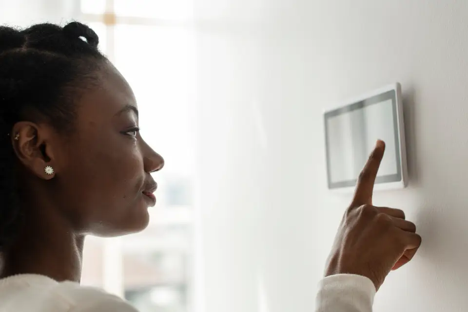 Women interacting with thermostat