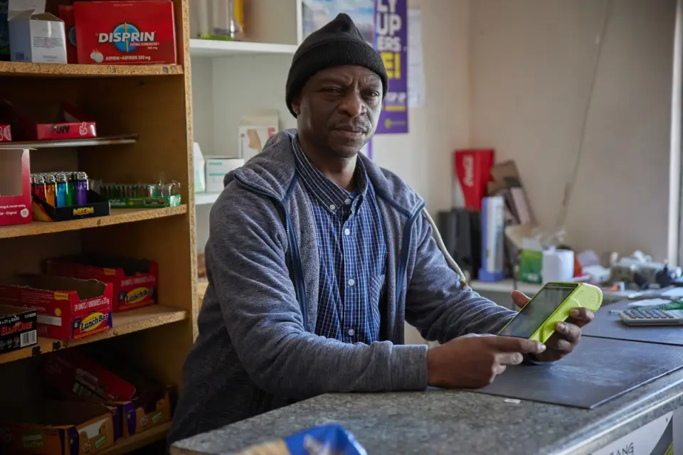 Store owner holding a lesaka fintech machine