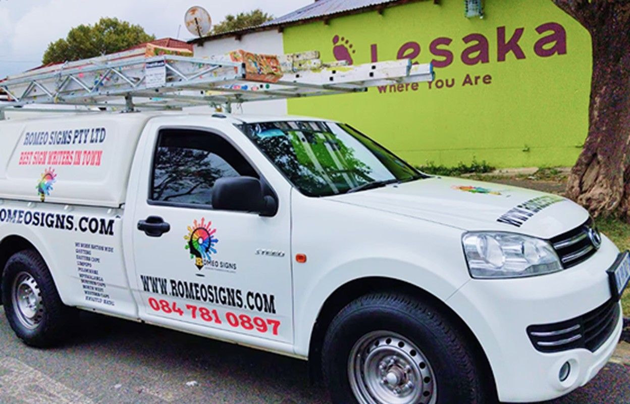 Romeo Signs vehicle branded with company logo parked outside their workshop.