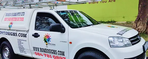 Romeo Signs vehicle branded with company logo parked outside their workshop.