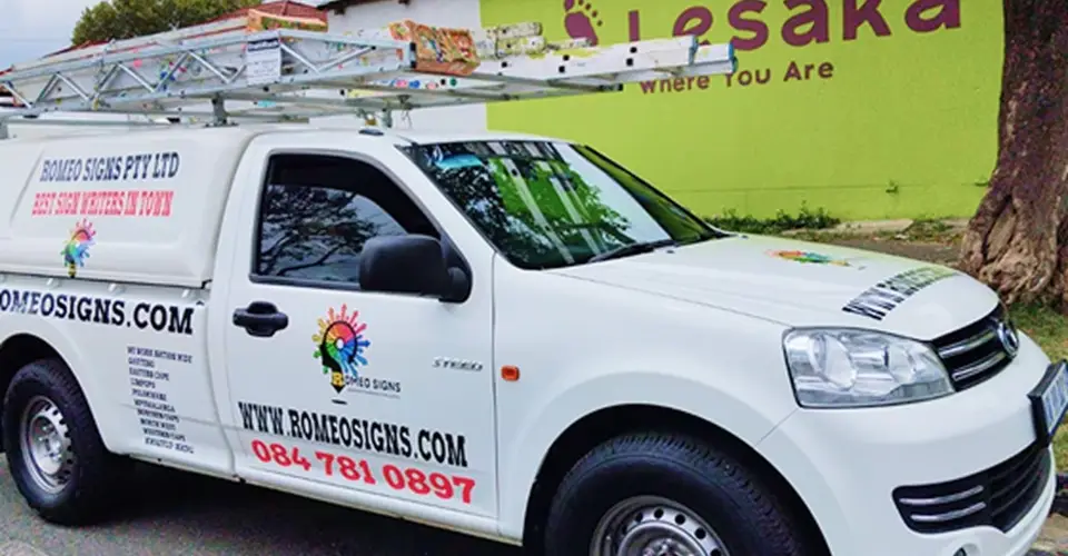 Romeo Signs vehicle branded with company logo parked outside their workshop.