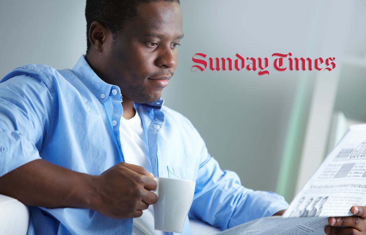 Man with coffee reading a newspaper