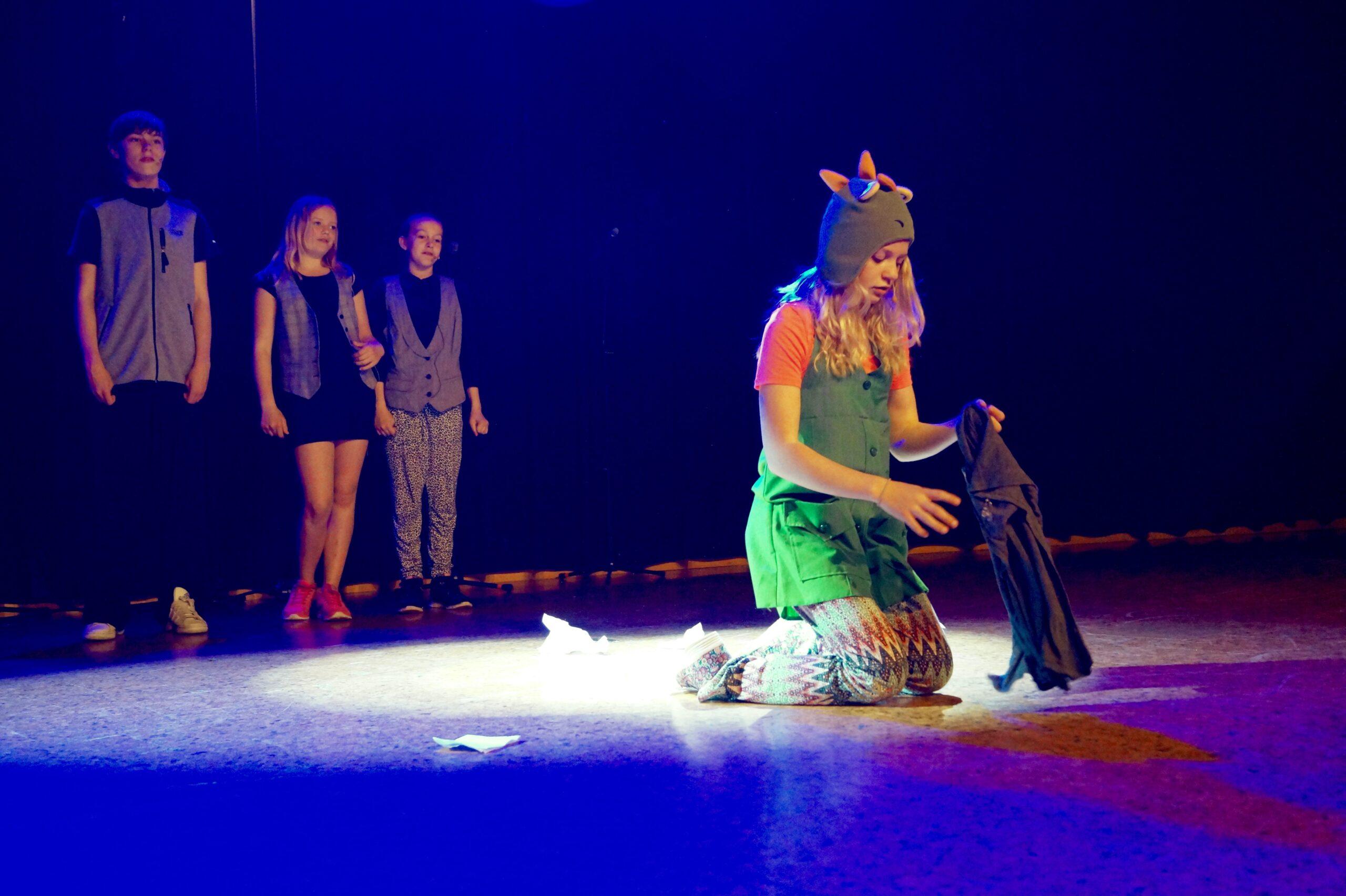 Elever på scen som spelar teater under en föreställning