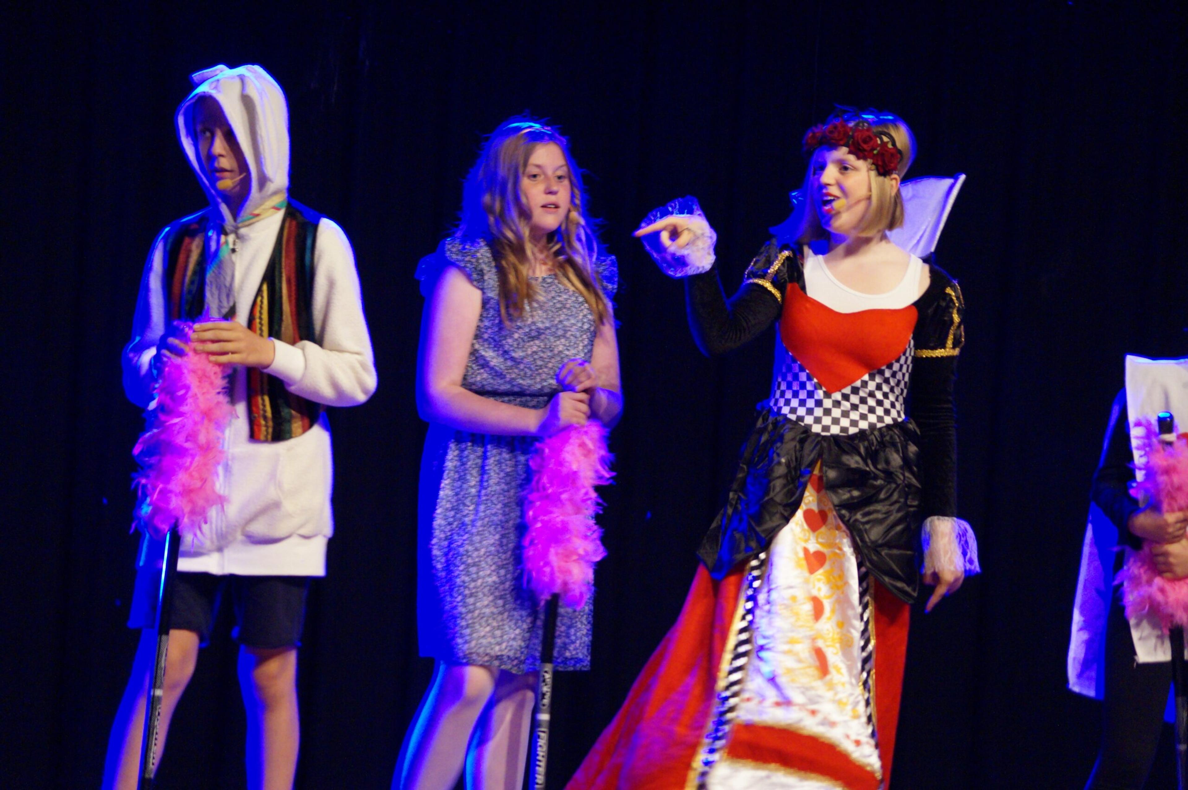 Elever som spelar teater i olika roller och kostymer 