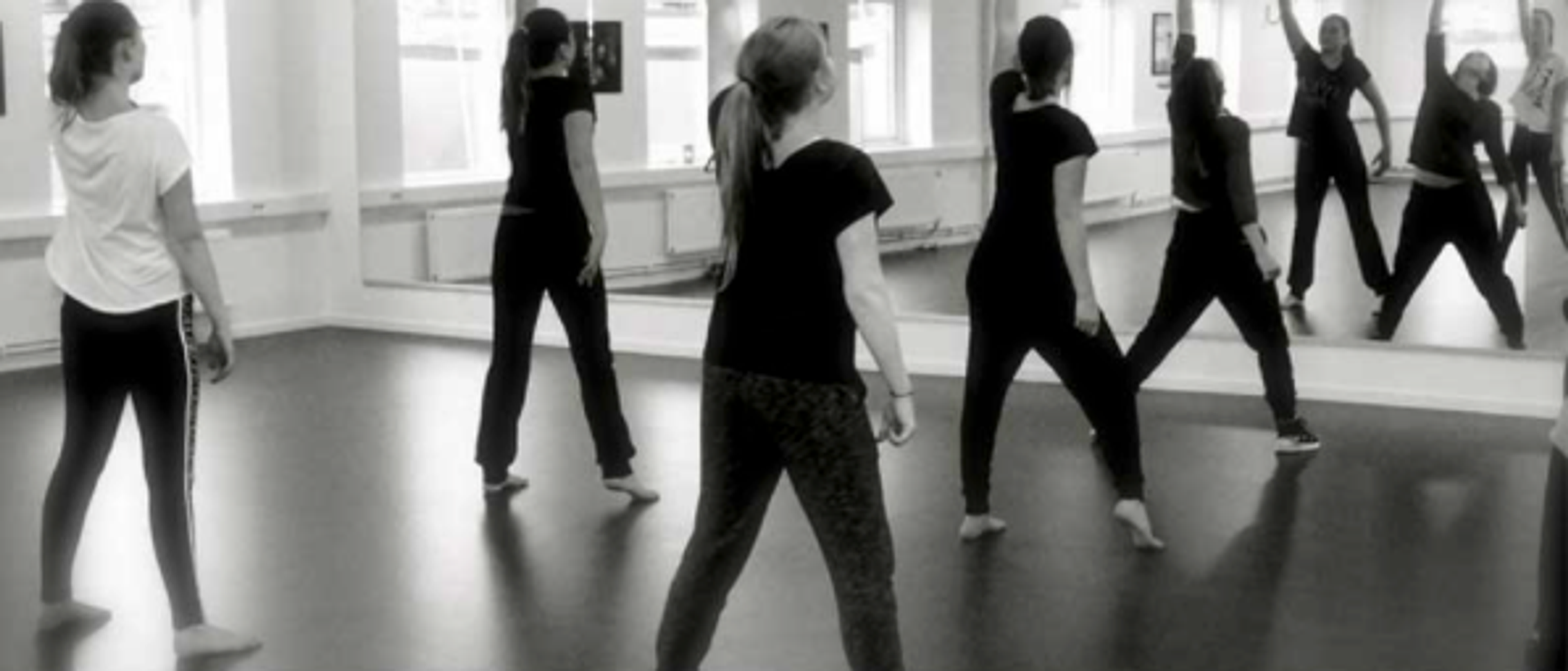 Elever som dansar i en danssal framför en spegel