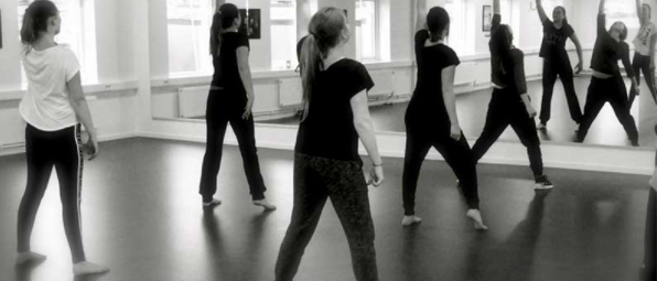Elever som dansar i en danssal framför en spegel