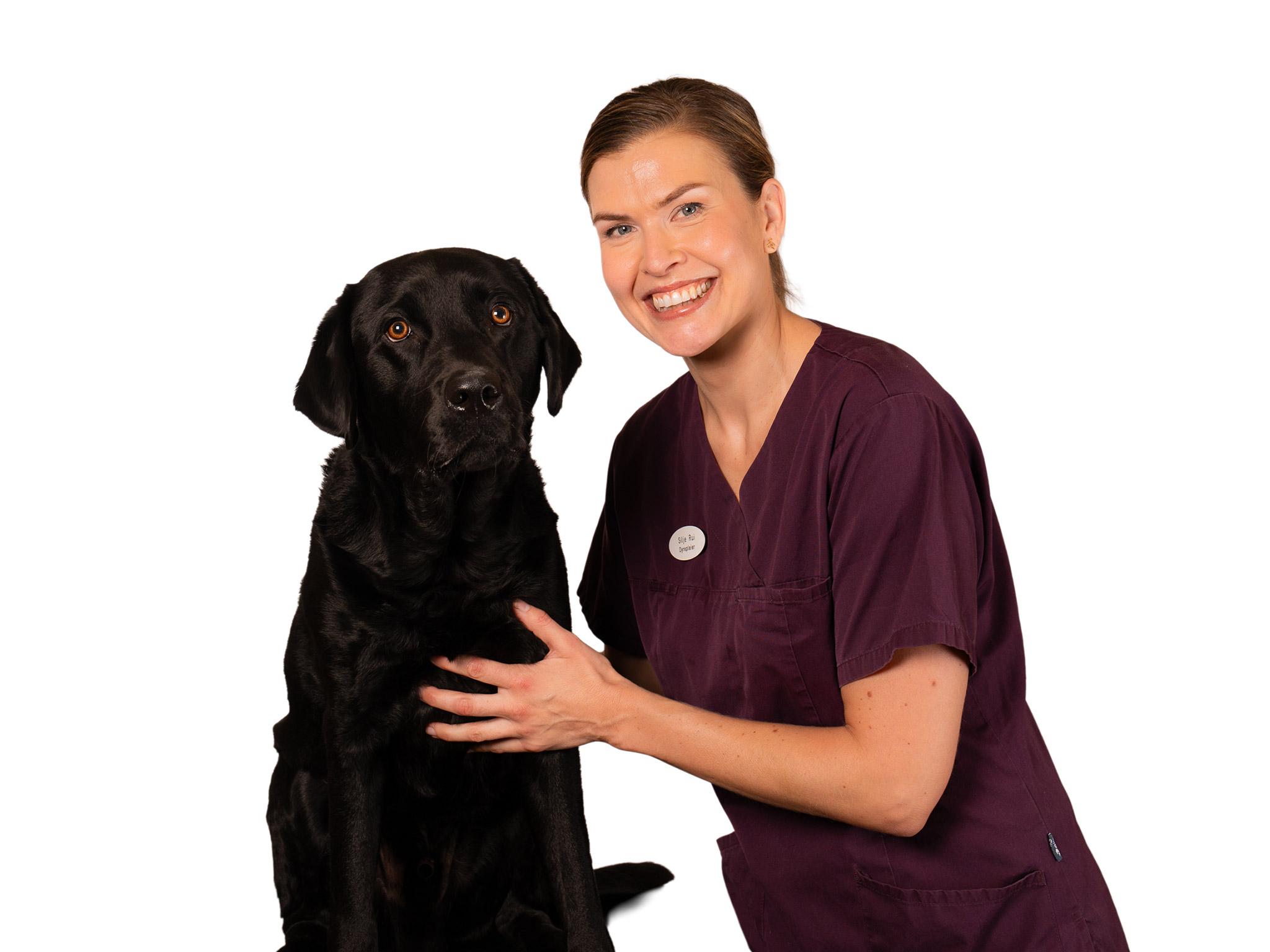 Silje Rui, dyrepleier ved Tønsberg Dyreklinikk, med en svart labrador