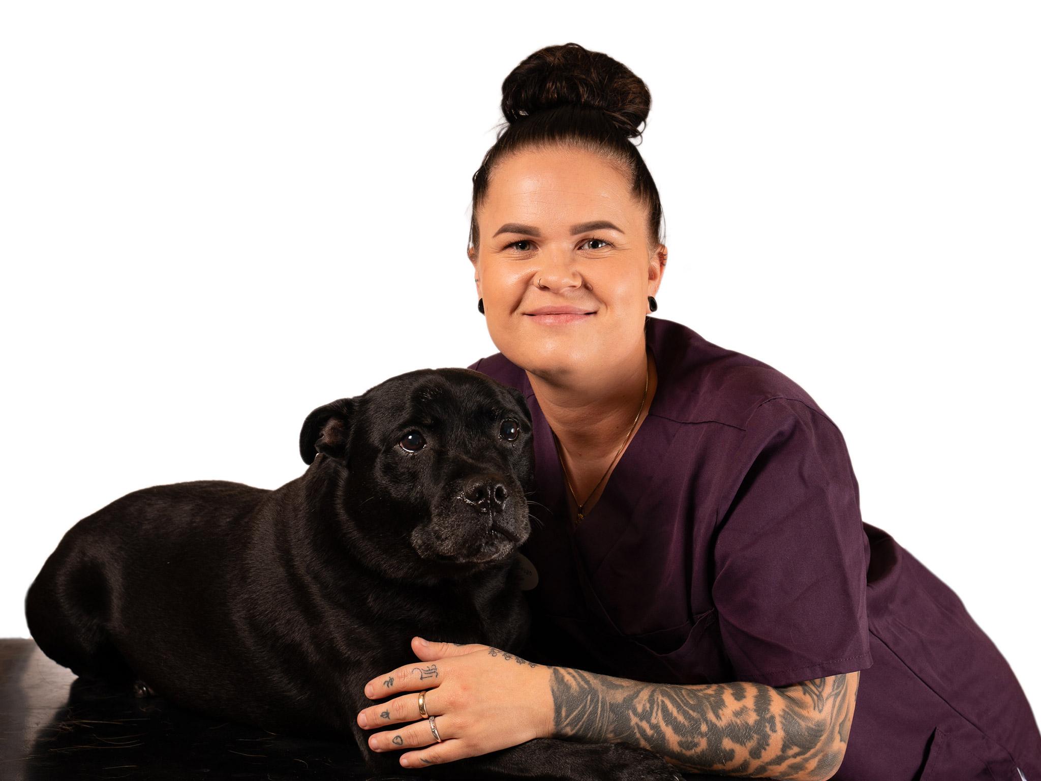 Ronja Hauan, dyrepleier ved Tønsberg Dyreklinikk, med en svart hund