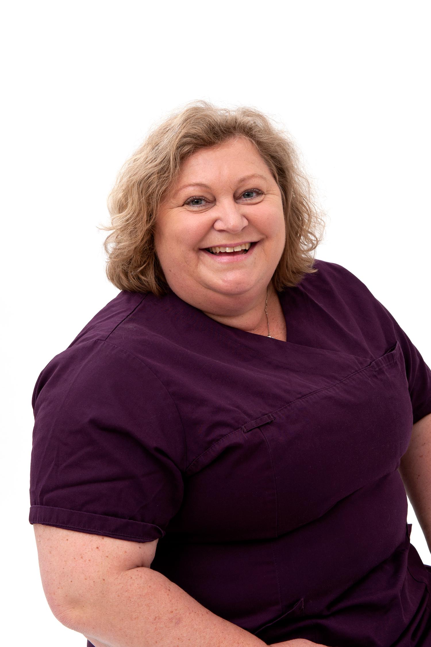 Bodil Sjøblom Horn, veterinær ved Tønsberg Dyreklinikk, i vinrød arbeidsskjorte mot hvit bakgrunn