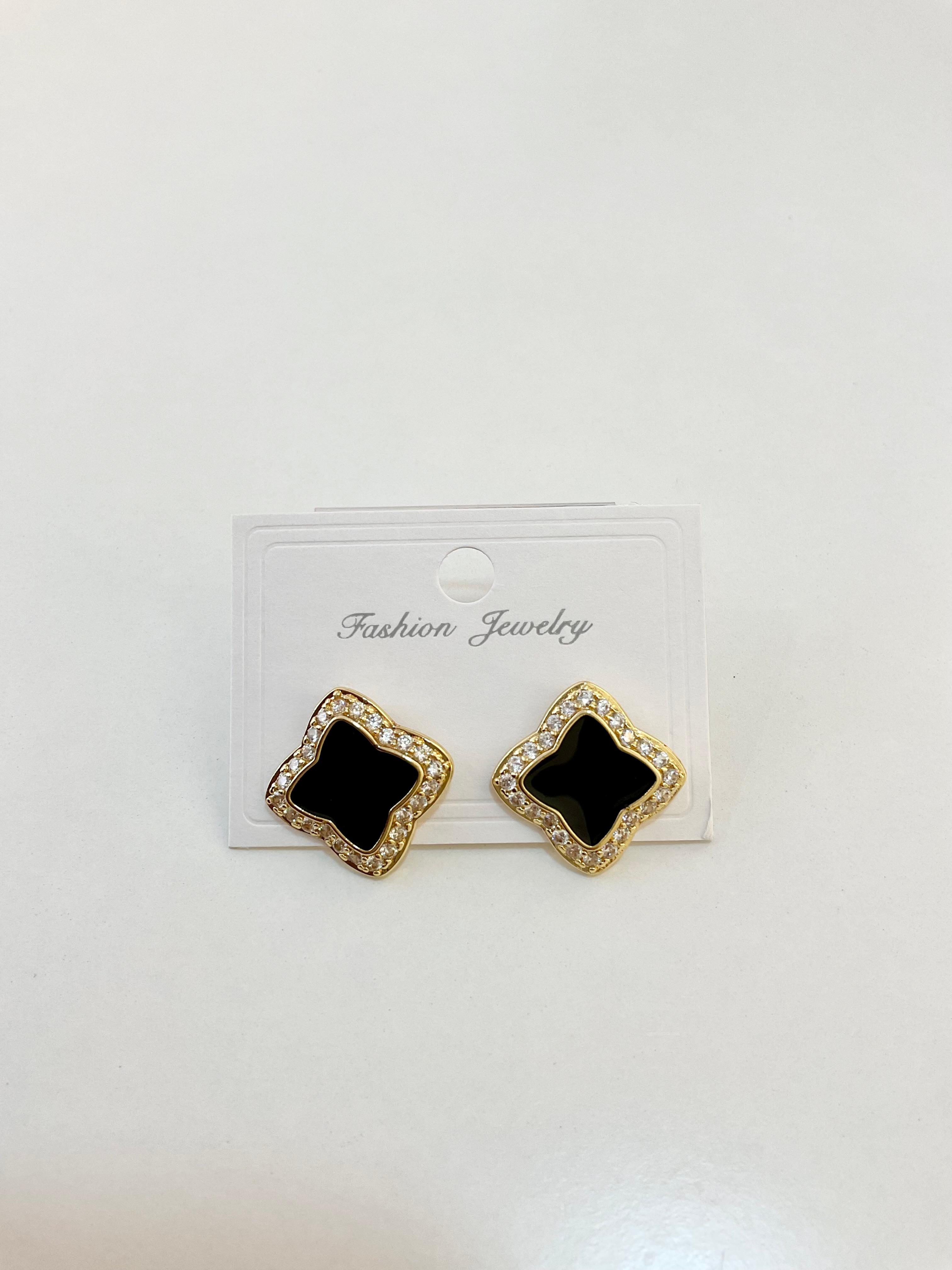 Earrings shaped like a black clover with crystal details