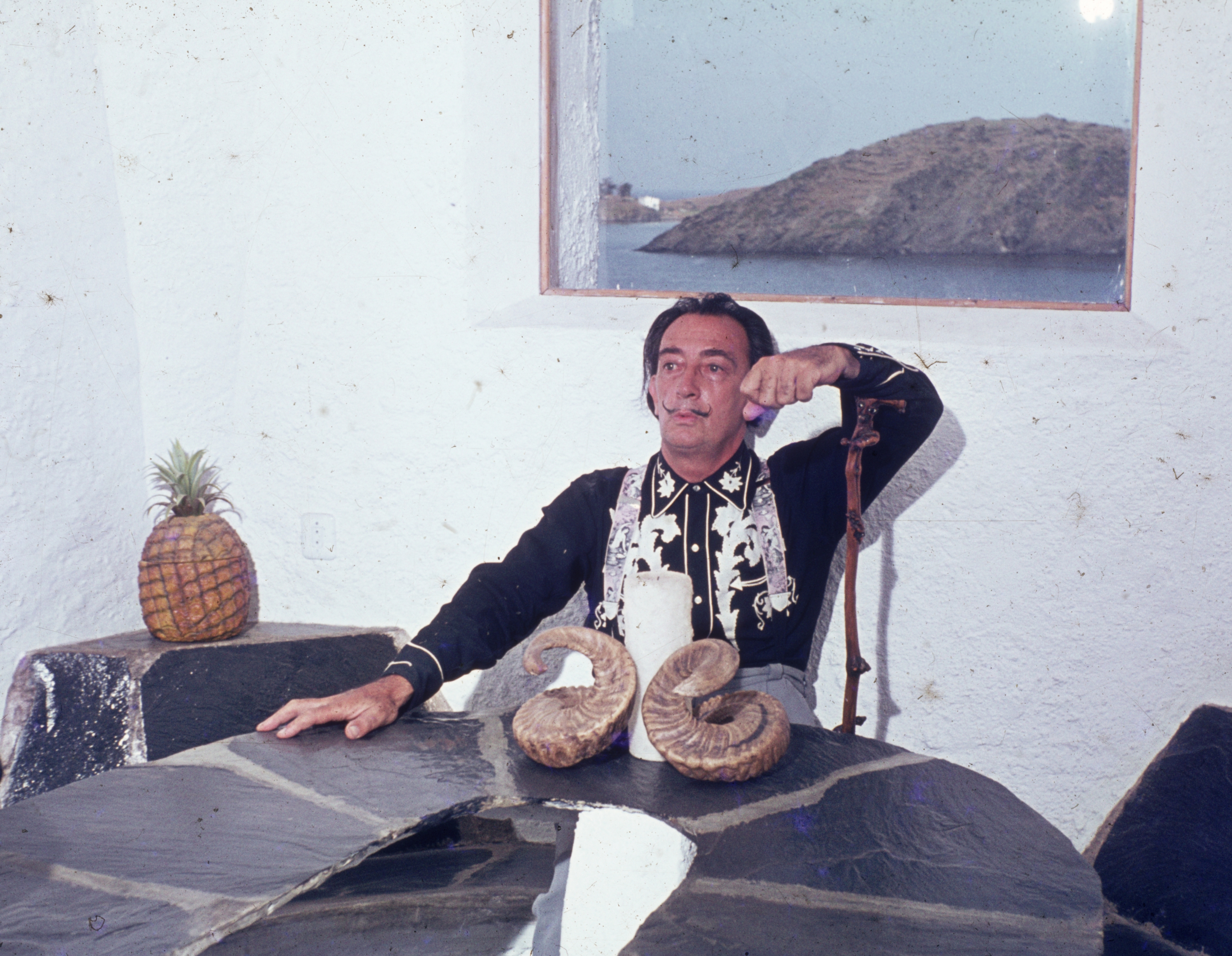 Salvador Dalí assis à une table