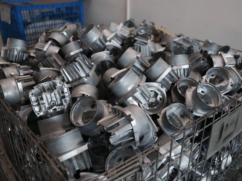 Die-cast aluminium LED work light housings in a material bin at the Tough Lighting factory
