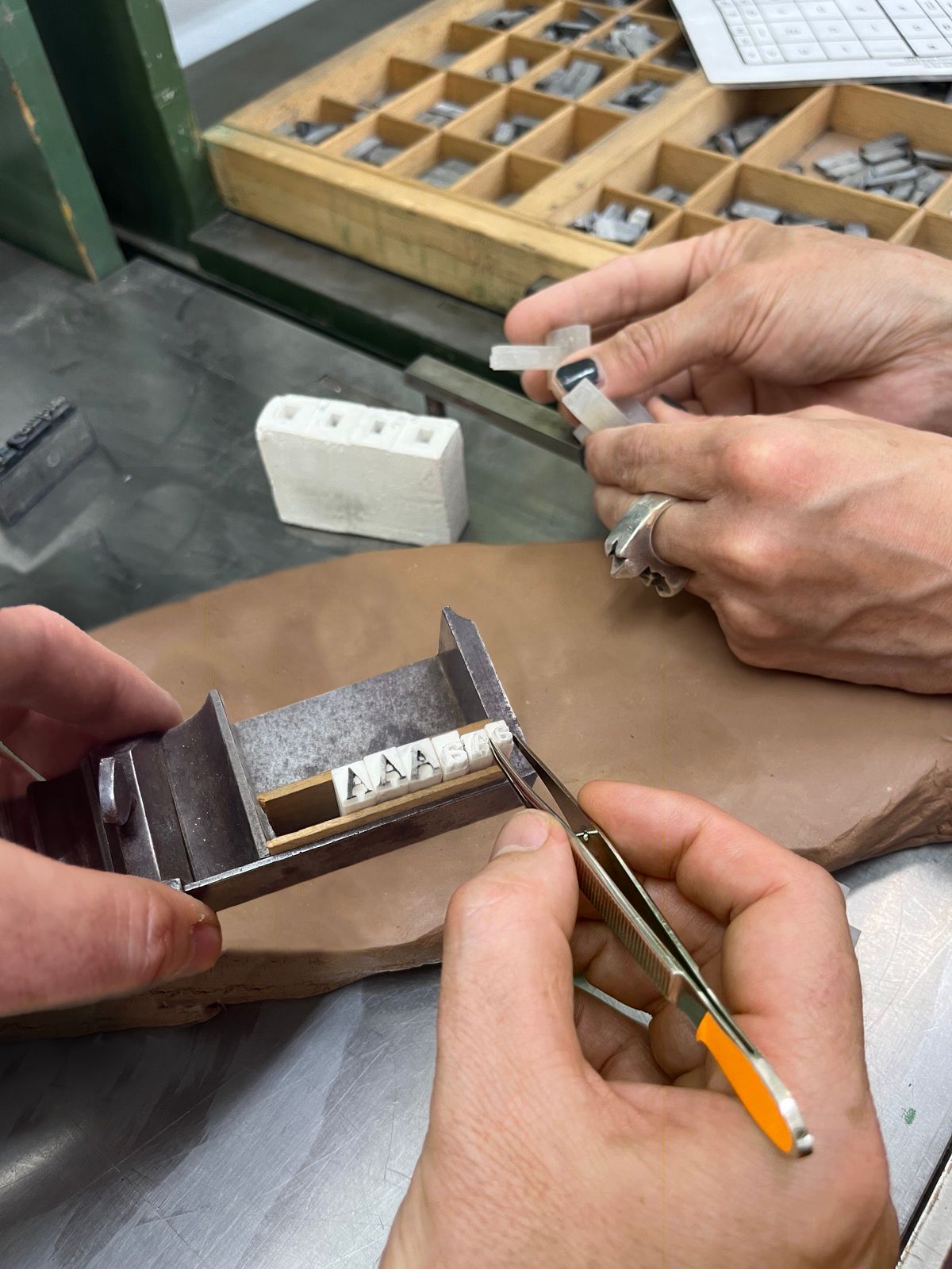 people working with ceramics tiles and ceramic letters 