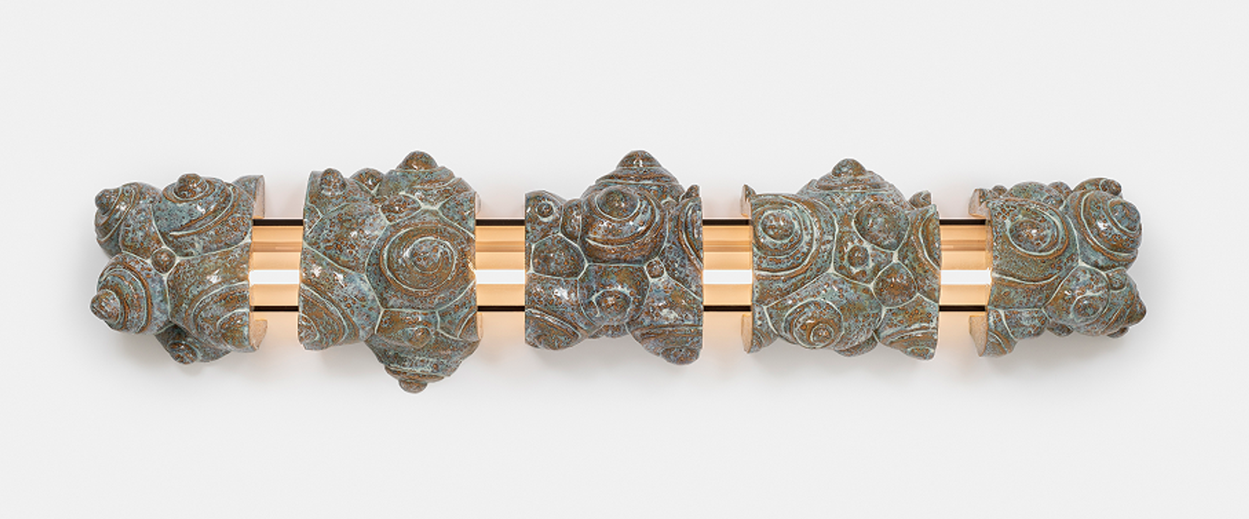 Sliced Cloud: five glazed ceramic fragments covered in spiral shells, threaded on a lit plexiglas rod.