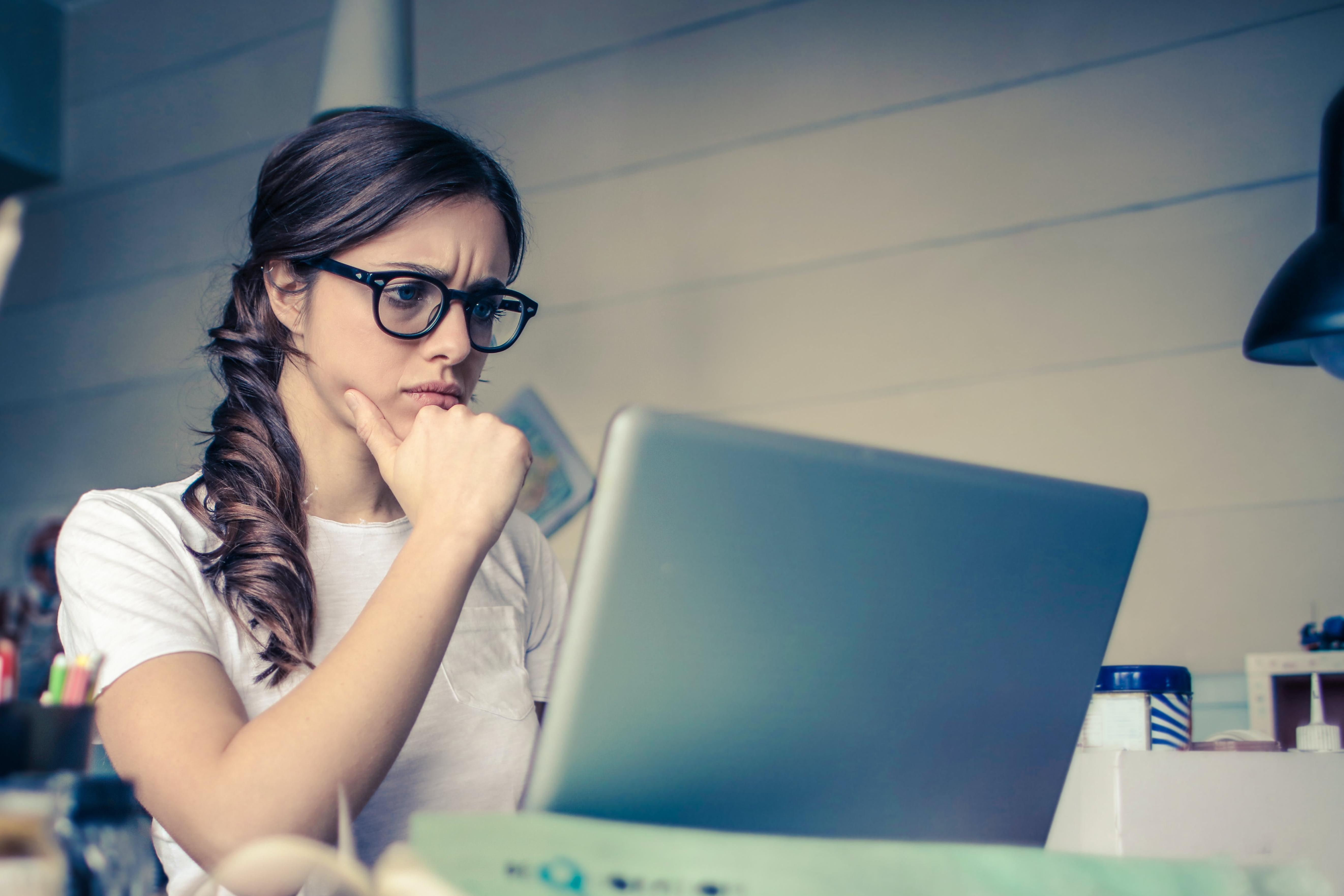 Woman at computer looking uncertain