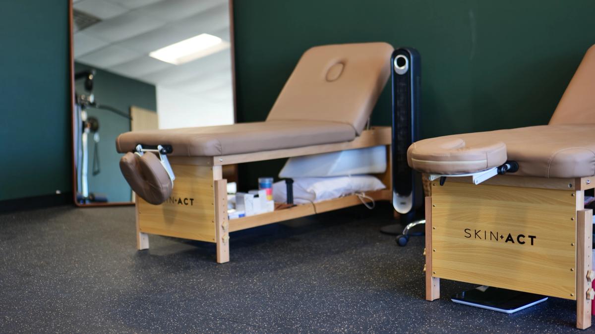 Treatment tables in the clinic against a forest green wall