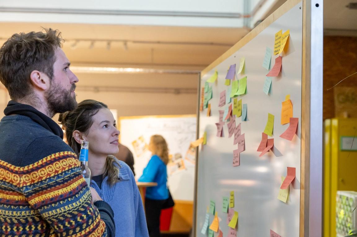 Zwei Teilnehmer*innen sehen sich das Bedürfnisboard an.