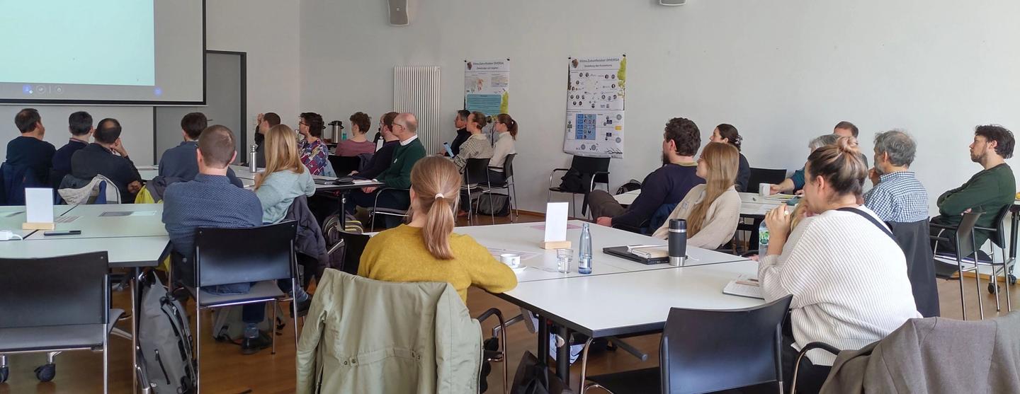Teilnehmende des DIVERSA-Kickoffs hören einem Impulsvortrag zu.