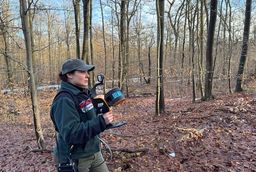 Mit dem Laserscanner in der Hand schreitet Dr. Sandra Peters die Untersuchungsfläche langsam ab.