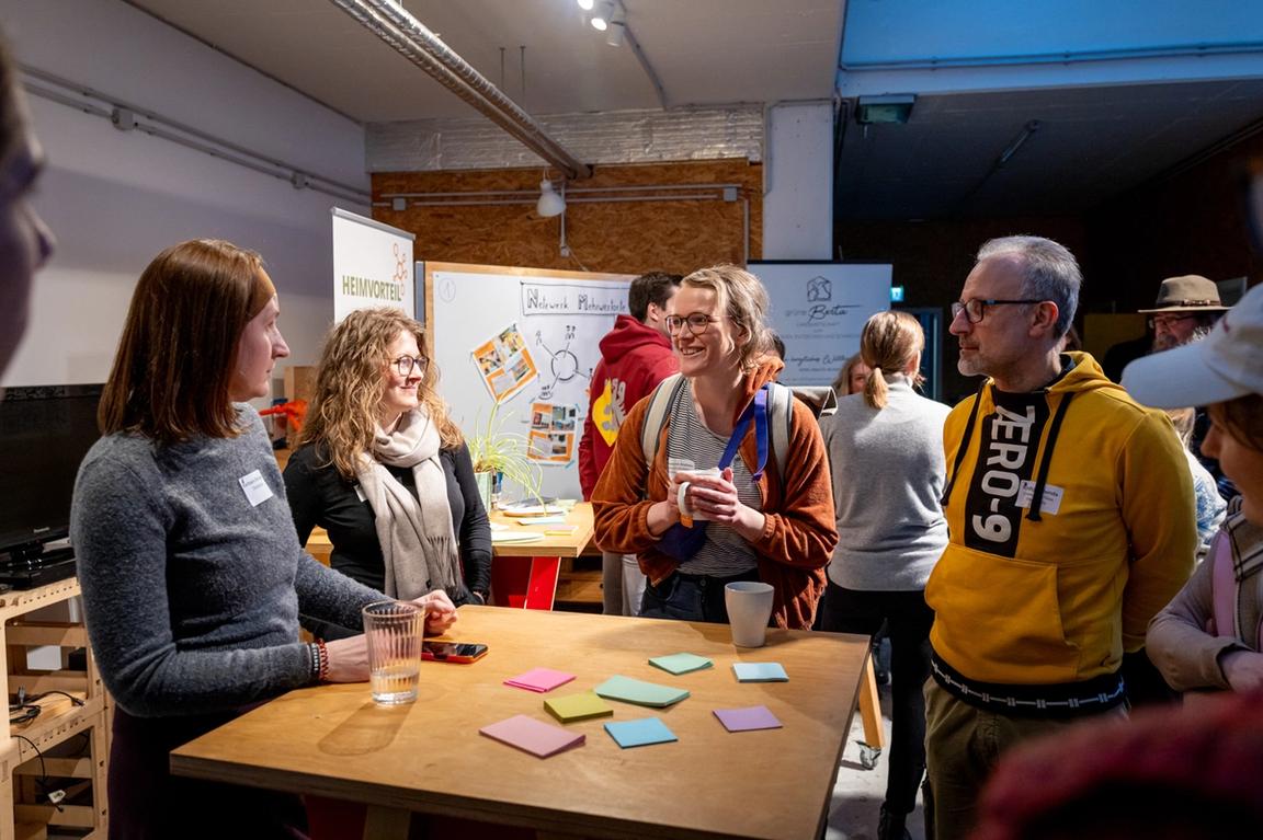 Teilnehmende im Gespräch mit Bedürfniszetteln vor sich.