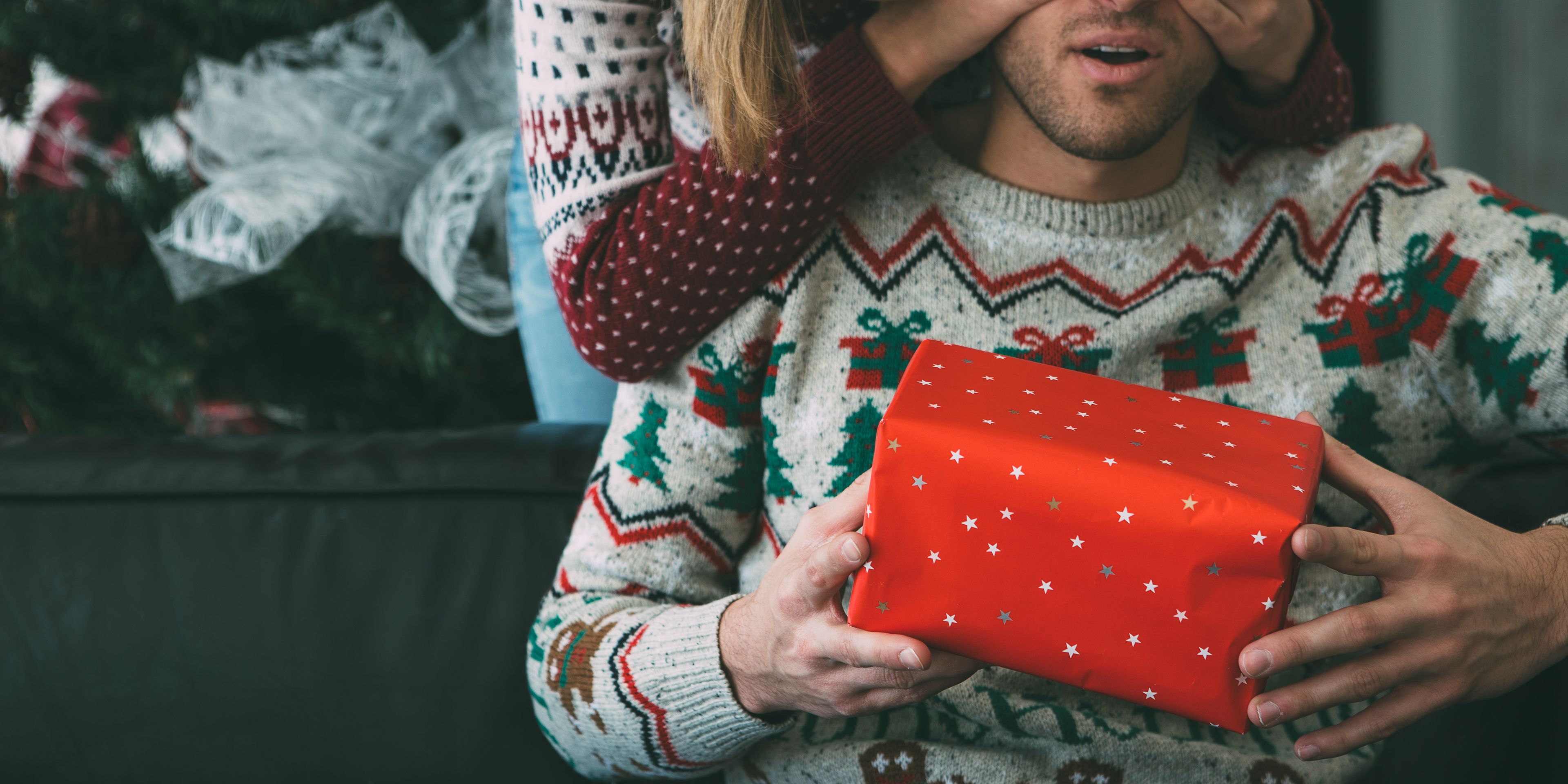 Woman surprising man with gift