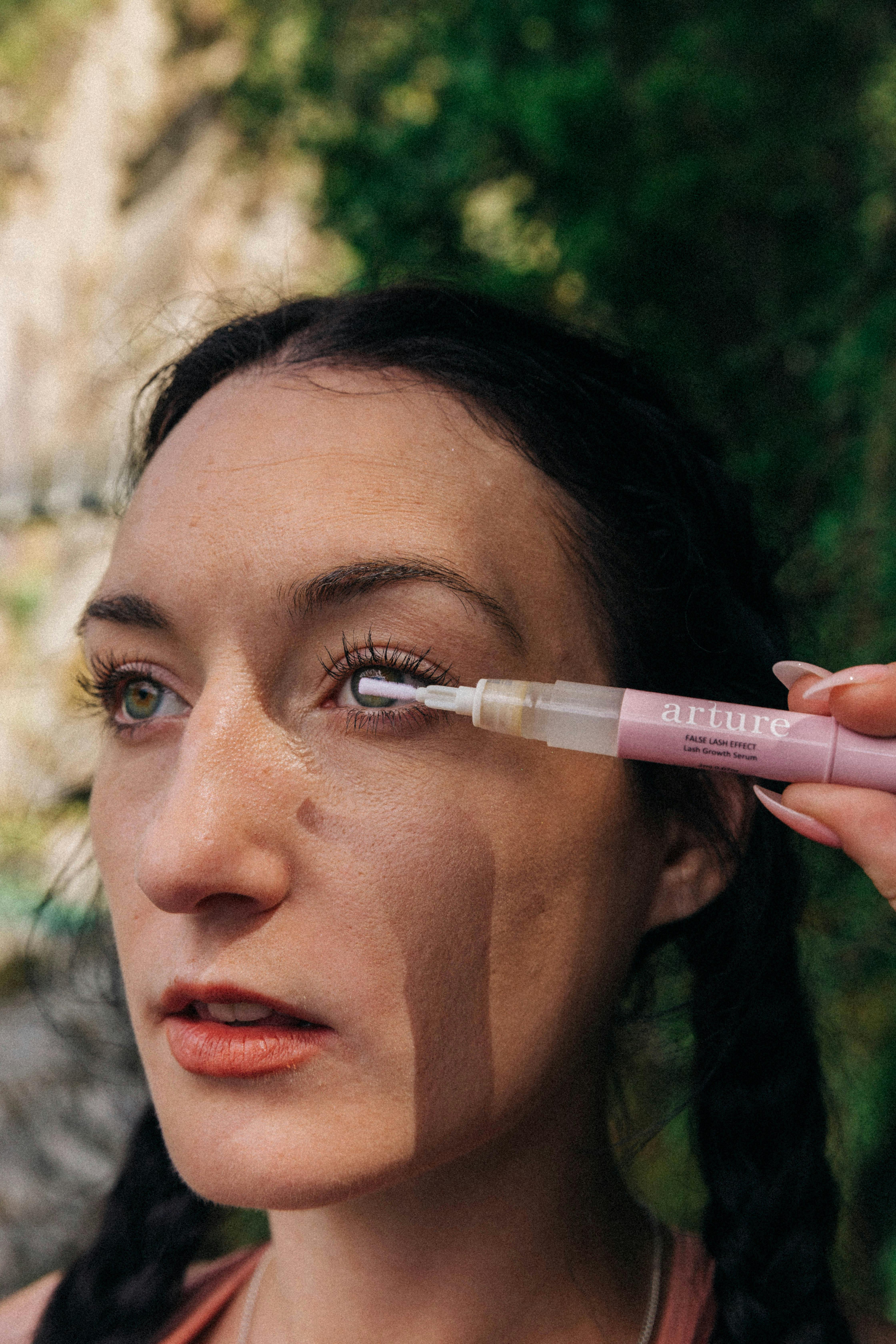 Woman using eyelash serum