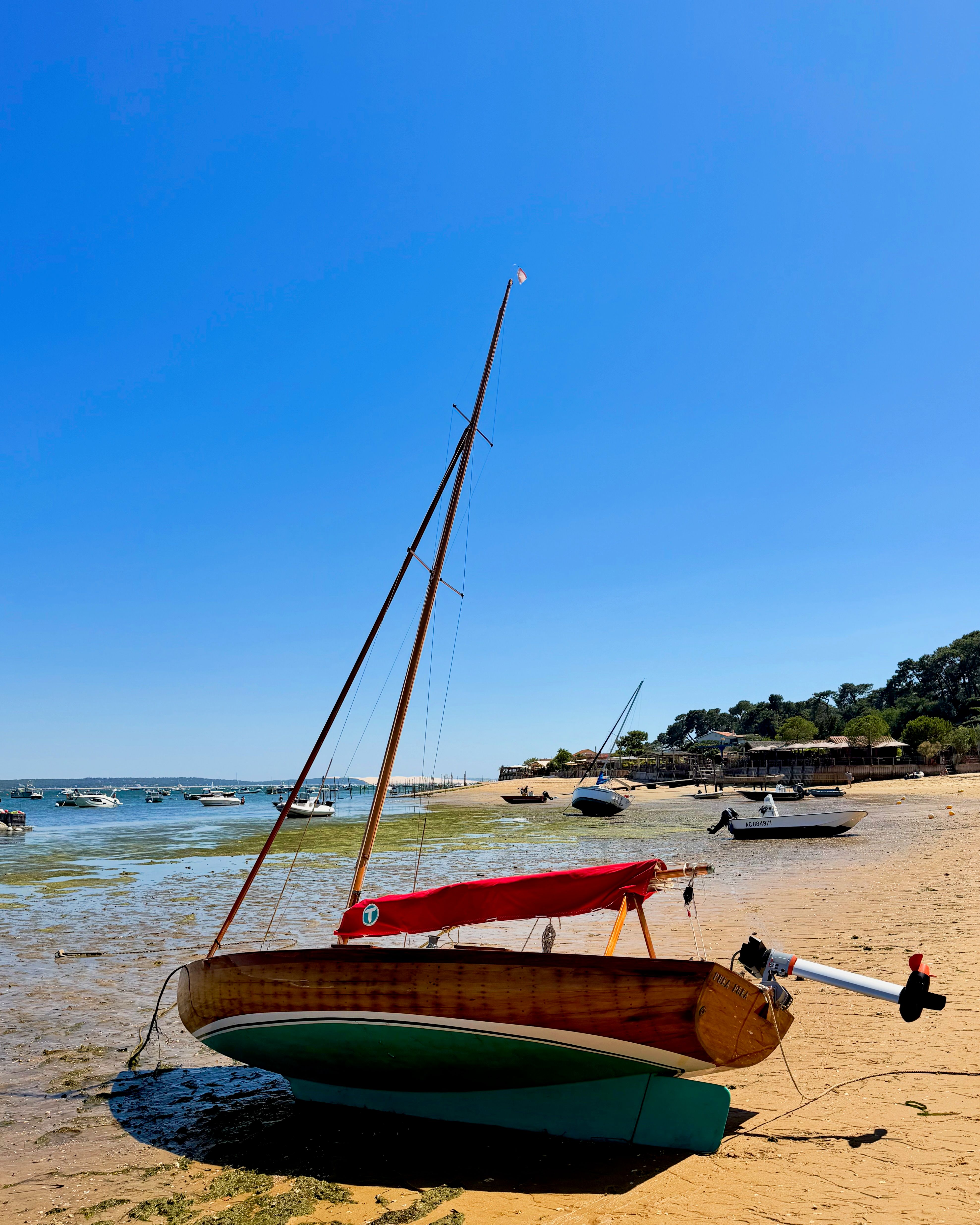 A sailboat on the beach during low tide