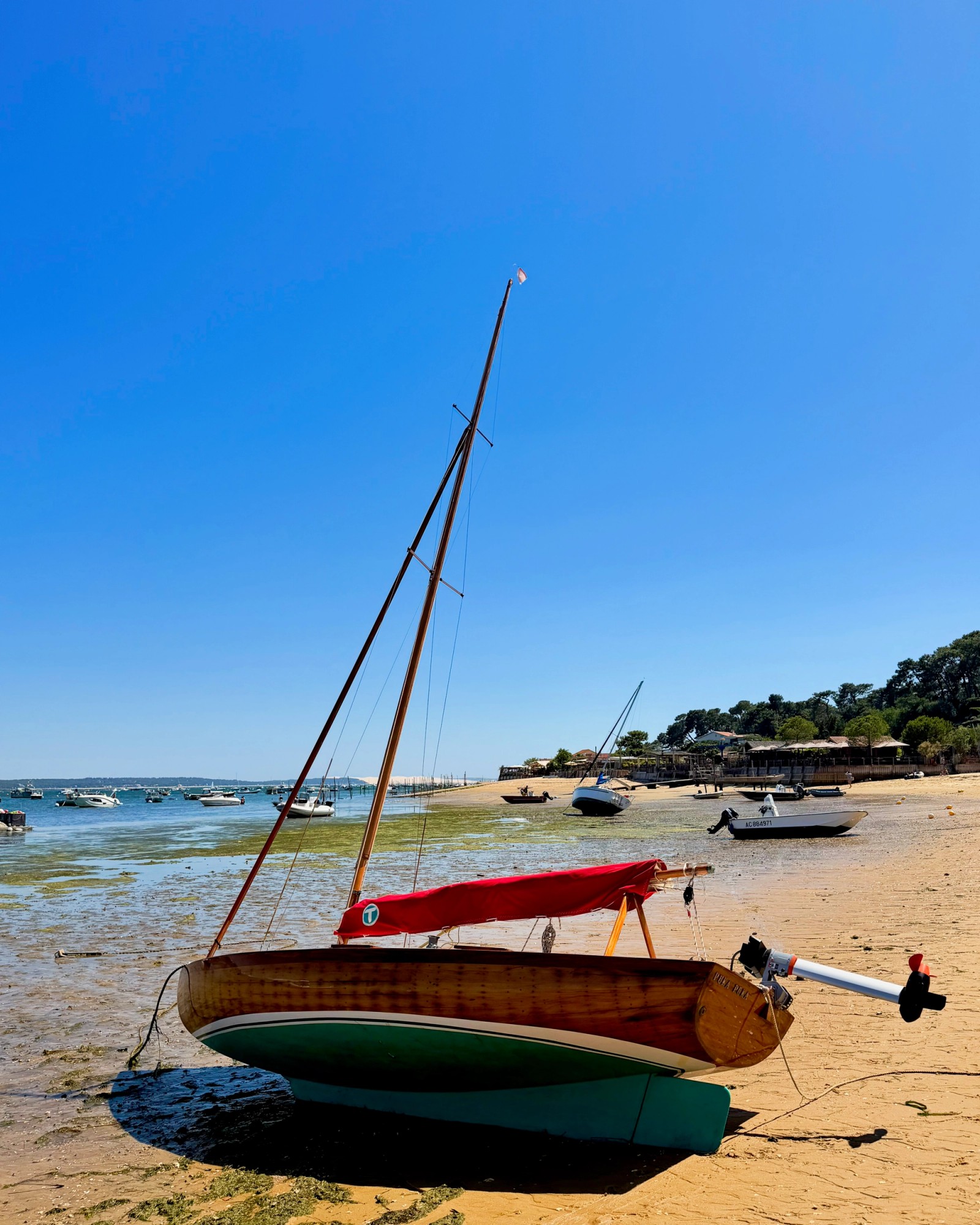 A sailboat on the beach during low tide