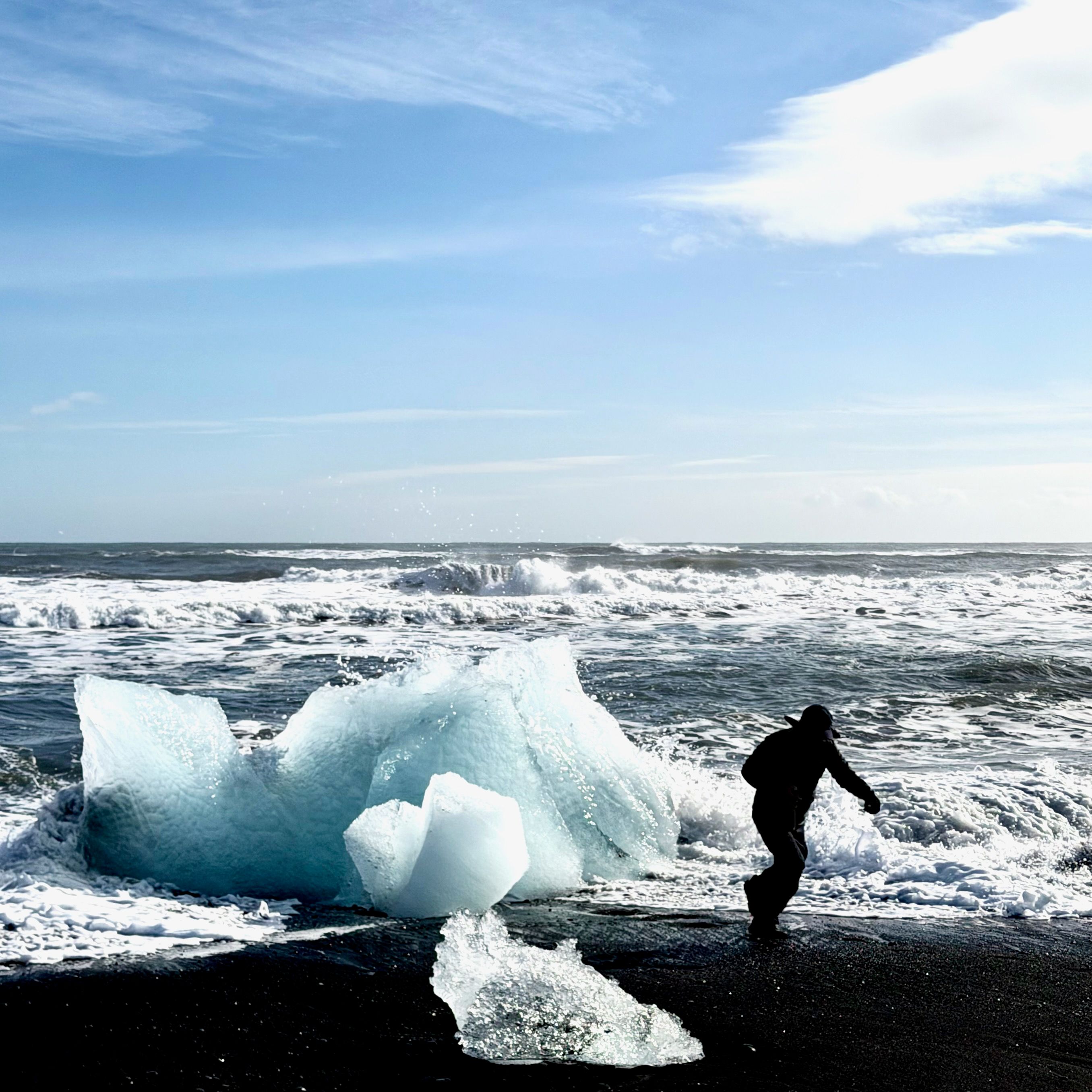 A man running from incoming waves because he is stupid and want to pose for instagram photos too close to a block of ice