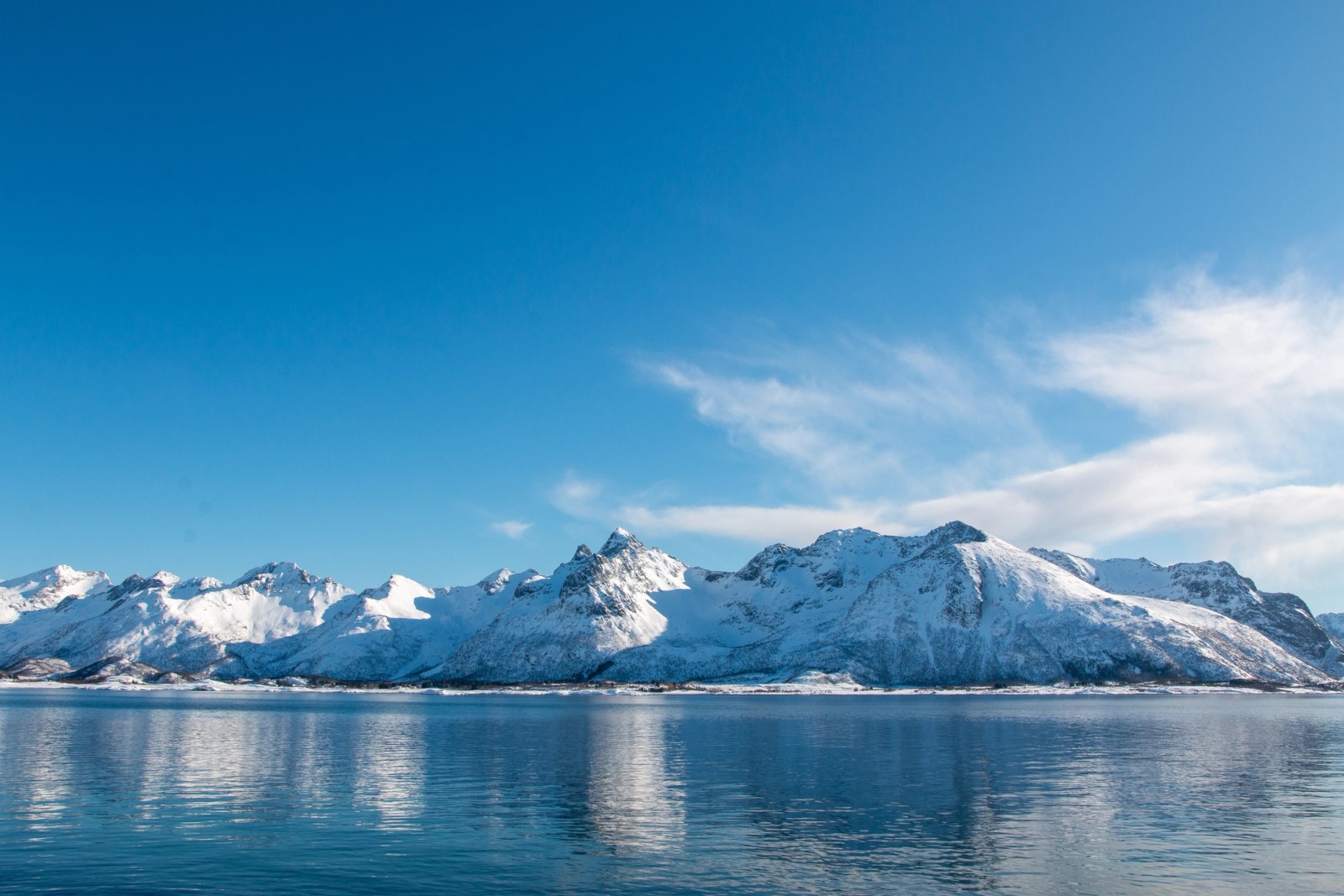 Steep, snowy mountains dropping straight into the ocean