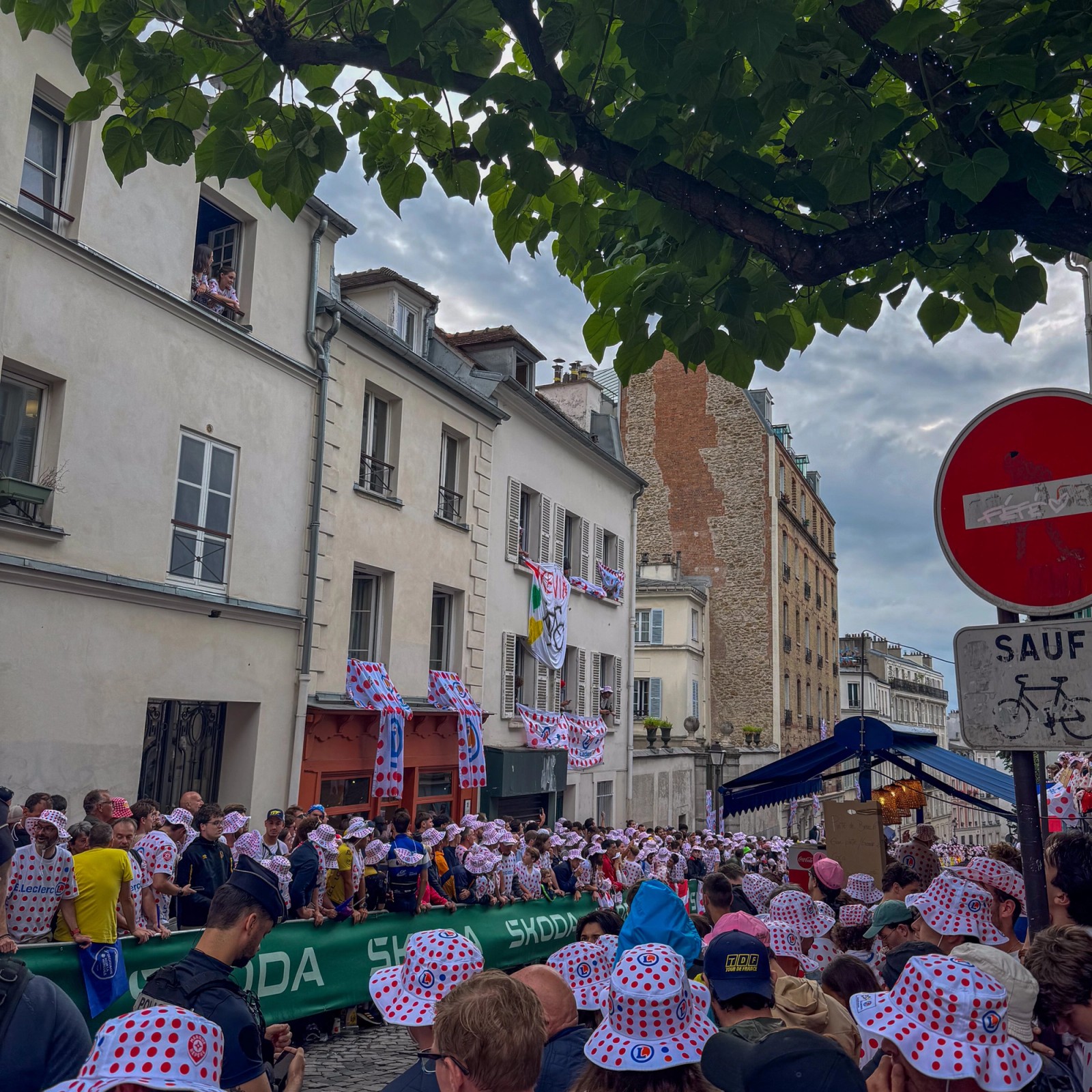 Spectators filling the narrow cobblestone street of Rue Lepic in Montmartre Paris, awaiting the cyclists fighting for the final stage win of Tour de France 2025