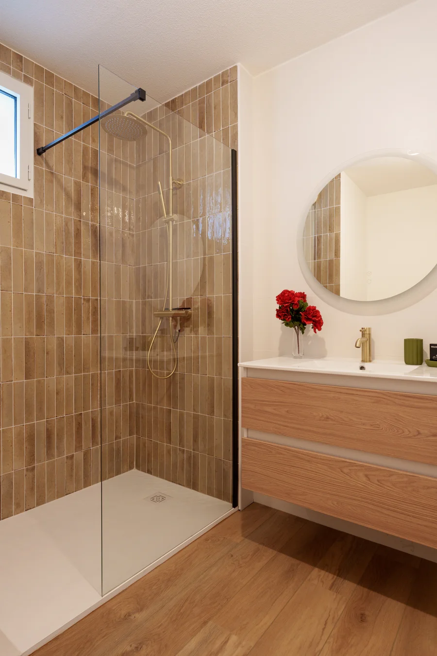 Salle de bain avec douche à l'italienne en zellige camel et robinetterie dorée