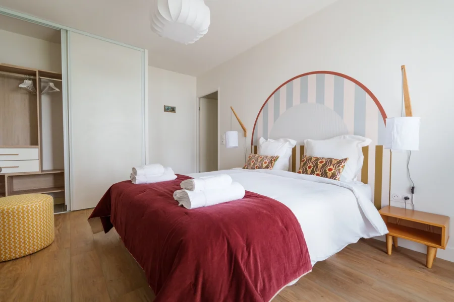 Seconde chambre avec dressing ouvert et pouf jaune